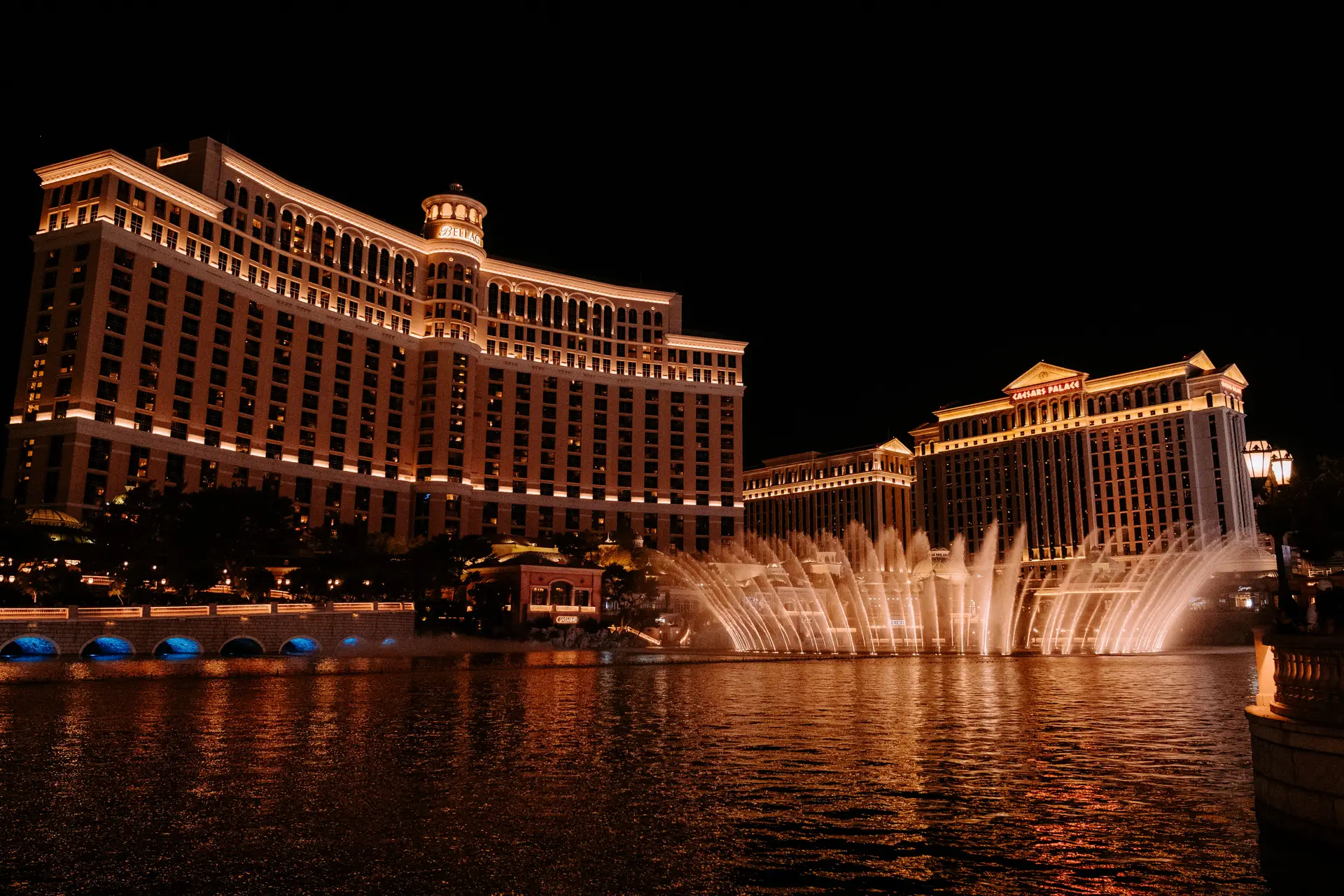 Spectacular resort architectural lighting casting gold and azure glows on serene waters